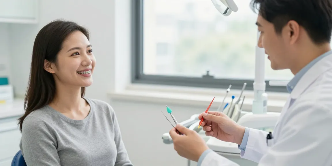 Adult smiling with coloured braces during consultation in a bright dental office.